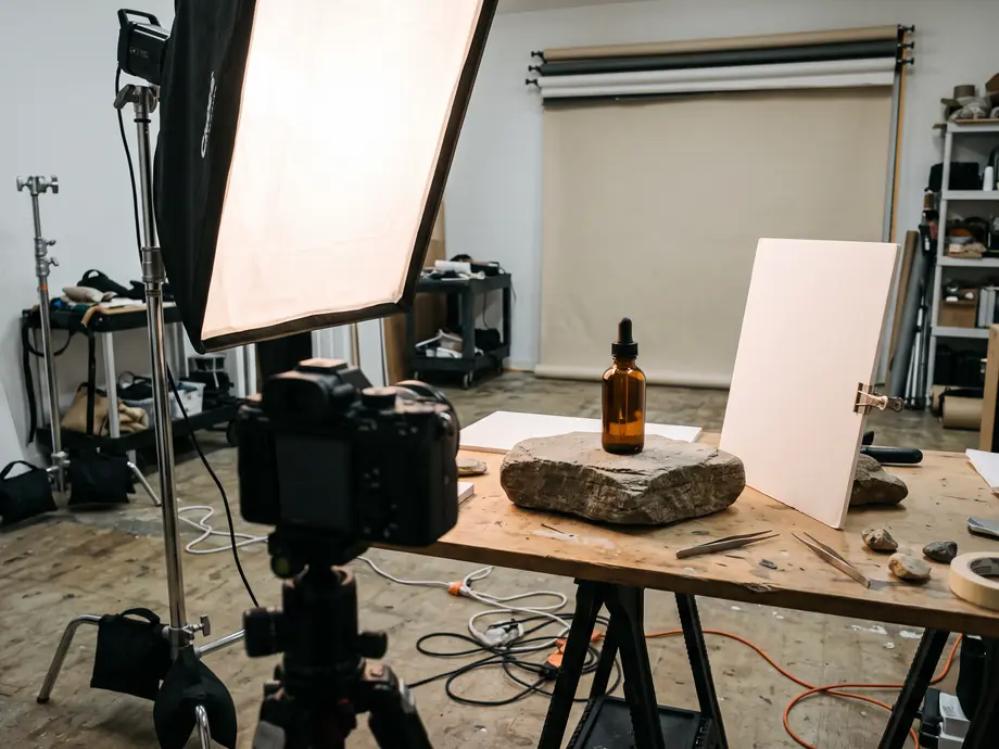Produktfoto-Aufbau mit Softbox, Kamera und Glasflasche auf einem Stein